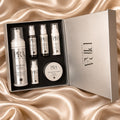 Six-piece PIRA skincare gift set in an open presentation box on champagne satin.